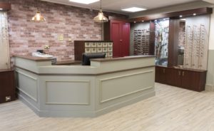 Angled traditional reception desk designed for Optical refit by Mewscraft